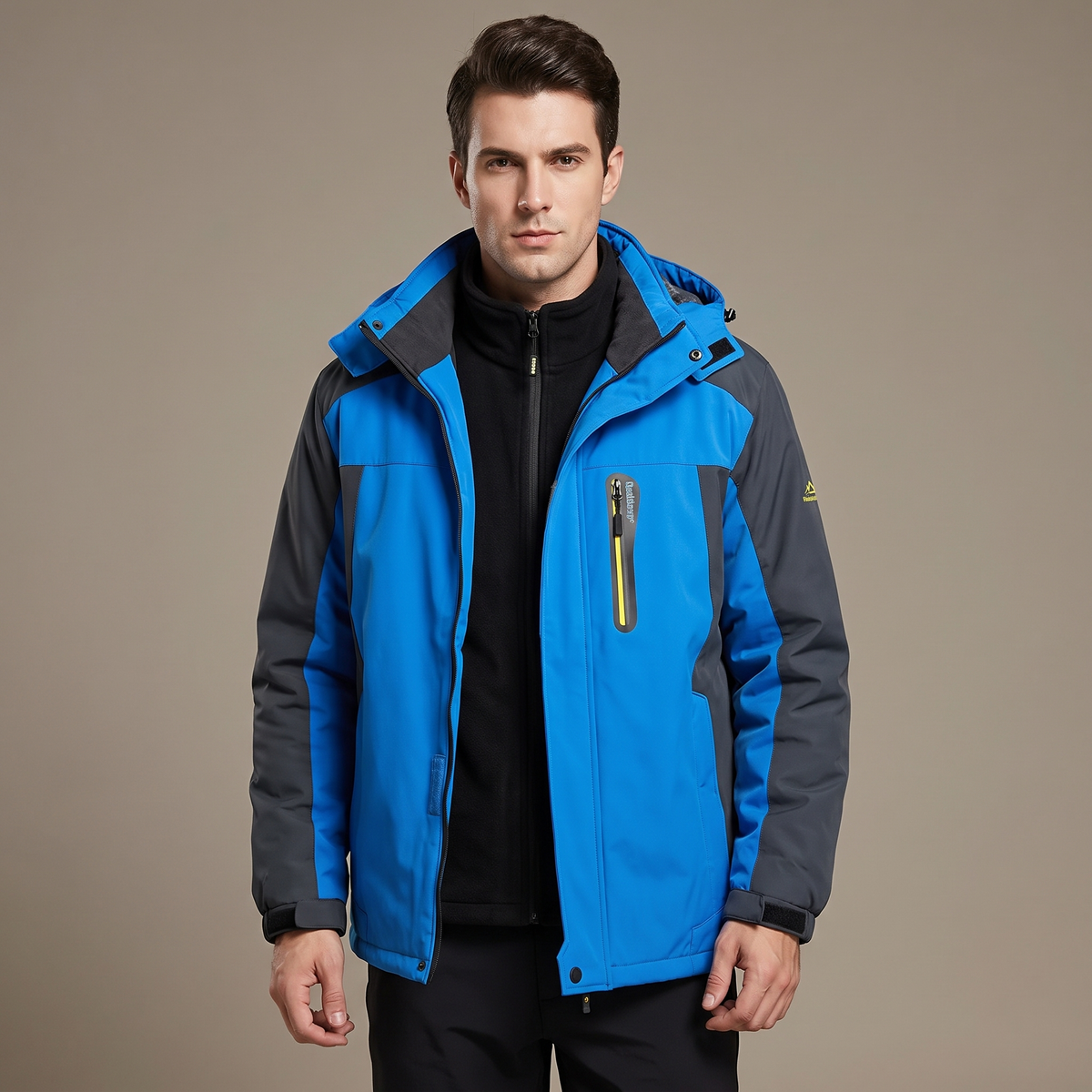Male model wearing a blue men's water-repellent winter jacket with fleece lining, studio shot